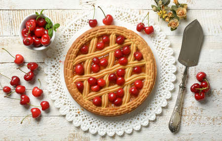 cherry tart with fruits around on white table - closeup