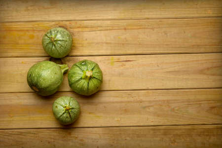 green round zucchini on wooden table - organic food - closeupの写真素材