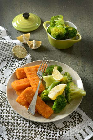 fish sticks with broccoli and lemon garnish - closeupの写真素材