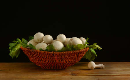 champignon mushrooms in the basket on black background - closeupの写真素材