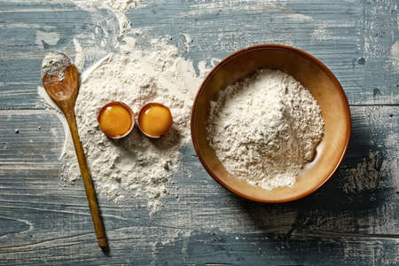 wheat flour and eggs on wooden table - horizontal - closeup