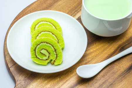 cake rolls on wooden plate with green tea milkの写真素材