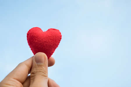 giving love concept with hand holding a red heart