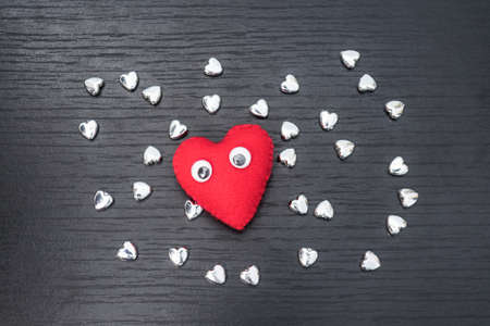 heart, red heart on black wooden background with small siver heart