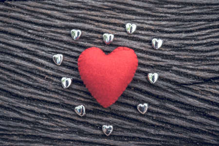 heart, red heart on black wooden background with small siver heartの写真素材