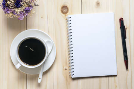 Flat lay desk with coffee, notebook and flowersの写真素材