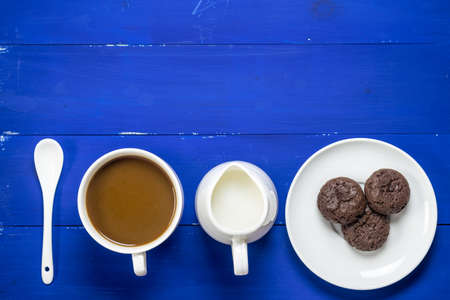 coffee and cookie on blue wooden background with flat lay imageの写真素材