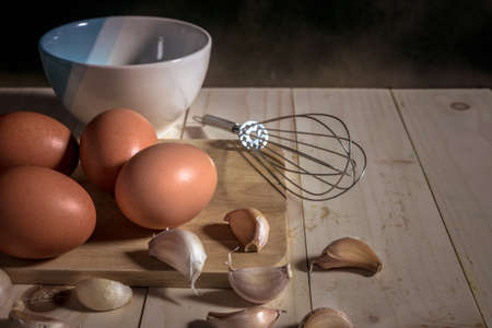 egg on wooden table and whisk, mystic photography and selective focus