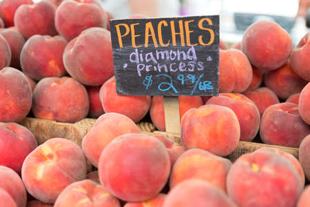 Close up view of Red ripe peaches, Diamond princess, with a price sign on the counter at Farmers Market in Bellevue.の写真素材