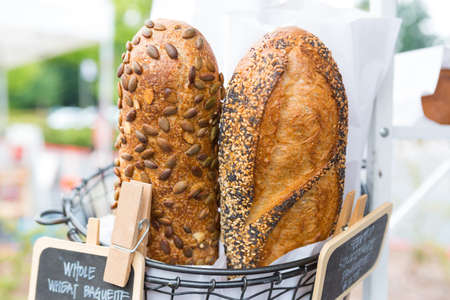 Crusty homemade whole wheat baguette for sale at the local farmers' market.の写真素材