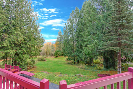 Exterior of a luxury home. Beautiful view from the deck wit red hand rails.