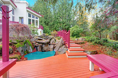 Backyard view of luxurious home with a Small pond Surrounded By Natural Stone inviting to Relaxing...