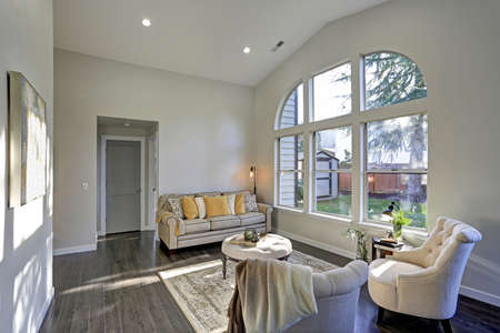 Sun filled family room in soft beige tones. The room is furnished with a lovely sofa topped with...