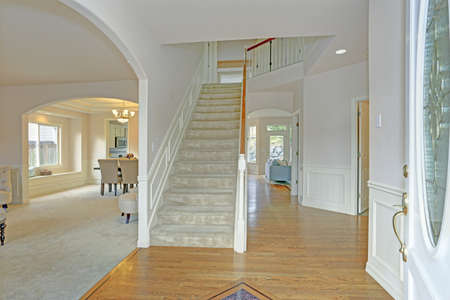 Bright foyer with white walls and staircase Lined with a board and batten trim.の写真素材
