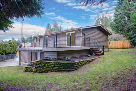 Stunning home exterior features neatly trimmed backyard with leveled landscape design.の写真素材