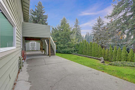 Backyard view of two story home with spacious patio are and green grass