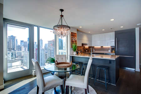 Light filled apartment interior with open floor plan features dining area with amazing view of...