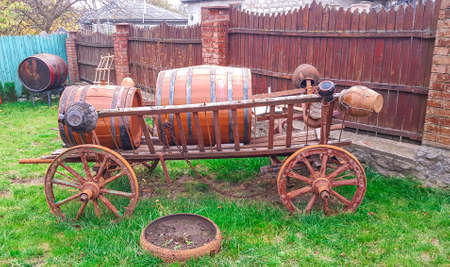 On a large cart with wheels a wine barrel. Country landscape.