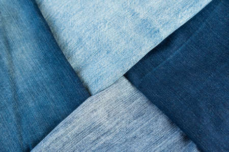 Different shades of blue denim fabric. Detail of several layers of jeans.の写真素材