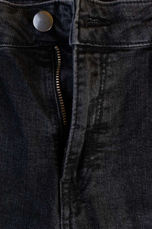 Detail of the button and zipper of a black denim pants.の写真素材
