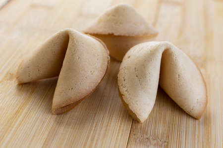 Chinese fortune cookies with golden and brown color and white backgroundの写真素材
