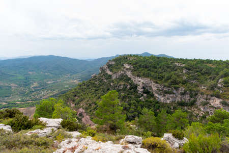 View of a mountain landscape in the Prades area in Catalonia with green and blue tones of the sky and cloudsの写真素材