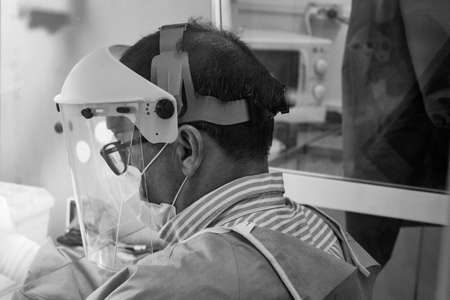 Biochemist sitting processing covid19 samples with mask face protectionの写真素材