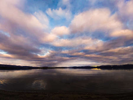 Clouds covering the sky over the coast of the lakeの写真素材