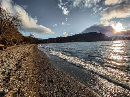 Sunset over the lake surrounded by mountainsの写真素材
