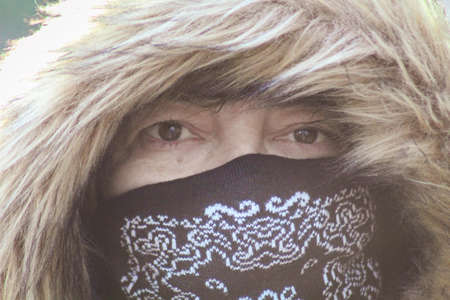 Portrait of woman with her covers mouth and nose in winterの写真素材