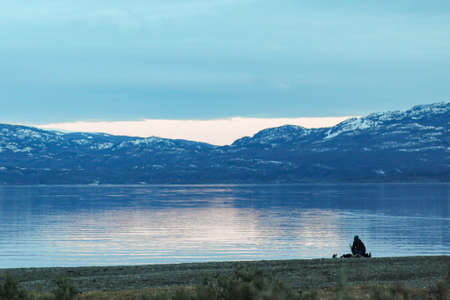 Person contemplating the moment of sunset over the bay