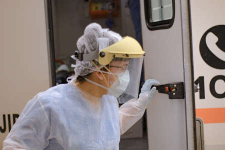 Female doctor getting out of the ambulance to attend an emergencyの写真素材
