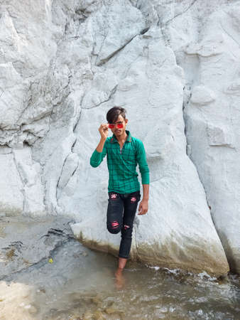 Handsome model man wearing white blank t-shirt with space for your logo or design. Mountain beautiful backgroundのeditorial素材