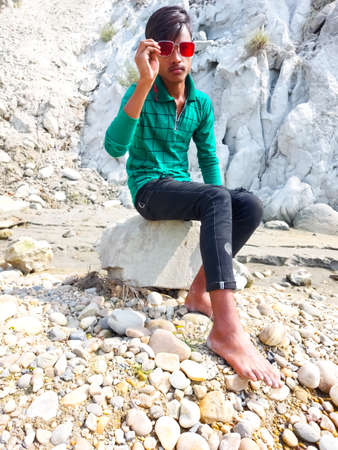 Parsa, Narayani Nepal - 16 march 2021: Handsome model man wearing colorful t-shirt with river  mountain beautiful backgroundのeditorial素材