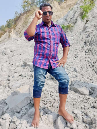 Parsa, Narayani Nepal - 16 march 2021: Handsome model man wearing colorful t-shirt with river  mountain beautiful backgroundのeditorial素材