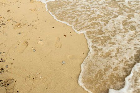 Footprint on sand with foam の写真素材
