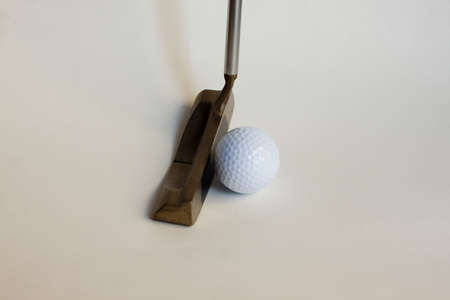 putter and ball against white background