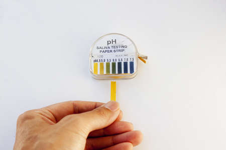 acidity testing strip against white backgroundの写真素材