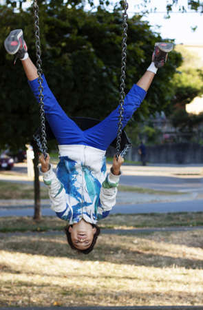 girl upside down on swing at parkの写真素材