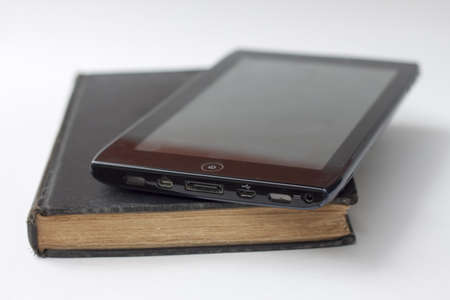 tablet atop book against white background