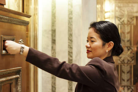 pretty asian businesswoman dropping off mailの写真素材