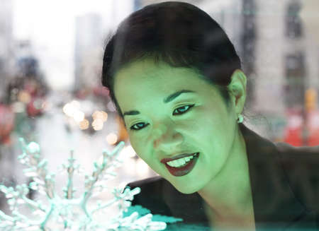 pretty asian lady admiring snowflake ornament - closeupの写真素材