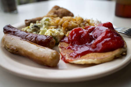 some pancakes and strawberries with sausage の写真素材