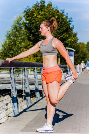 fitness girl leg stretch at railing