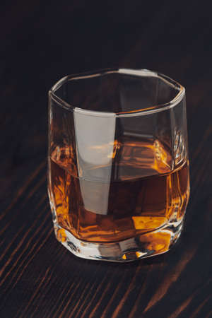 Studio shot of glass with alcohol. Rustic wooden background. Close upの写真素材