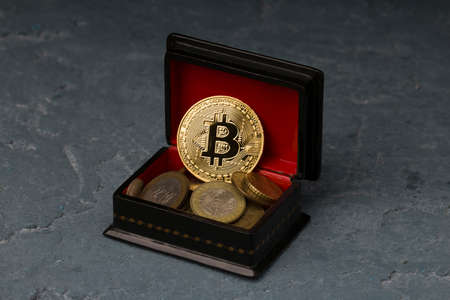 bitcoin lies on red casket base. Cryptocurrency in the form of coin