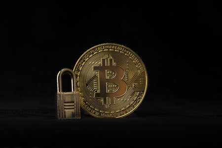 Gold coin with padlock on black background. bitcoin security conceptの写真素材