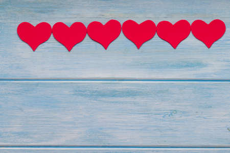 Red hearts on blue wood. some red hearts on blue wooden backgroundの写真素材