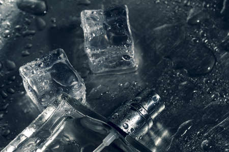 perfume bottle lying on ice cubes. close up viewの写真素材