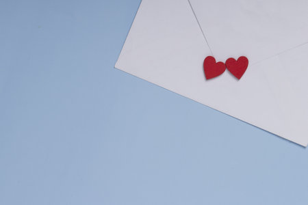Valentine day greeting concept. Envelope and two red hearts on blue background. Gift, message for...